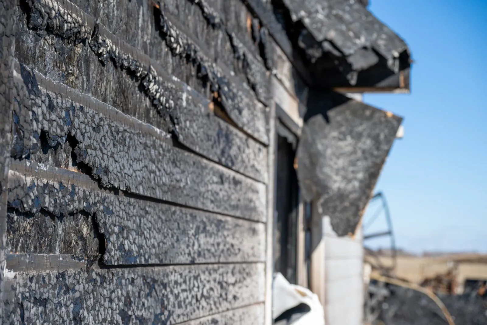 Charred siding and framing before fire damage repair in Phoenix, AZ
