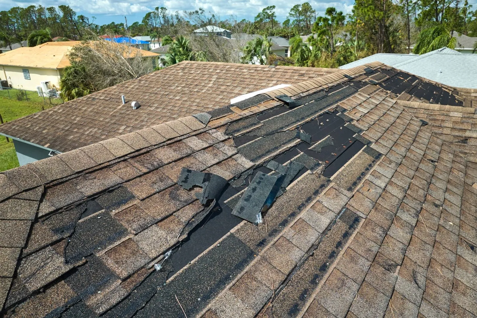 Wind damaged roof shingles before storm damage repair in Phoenix, AZ